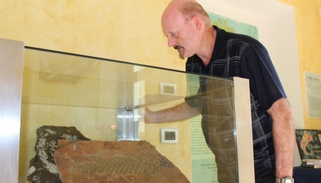 Il paleontologo Piero Damarco davanti a una teca del Museo astigiano (Foto arc. Museo) 