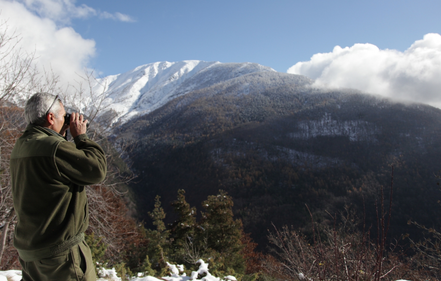 Guardiaparco che osserva con il binocolo al Colletto del Gran Faetto - foto arch. EGAP delle Alpi Cozie  